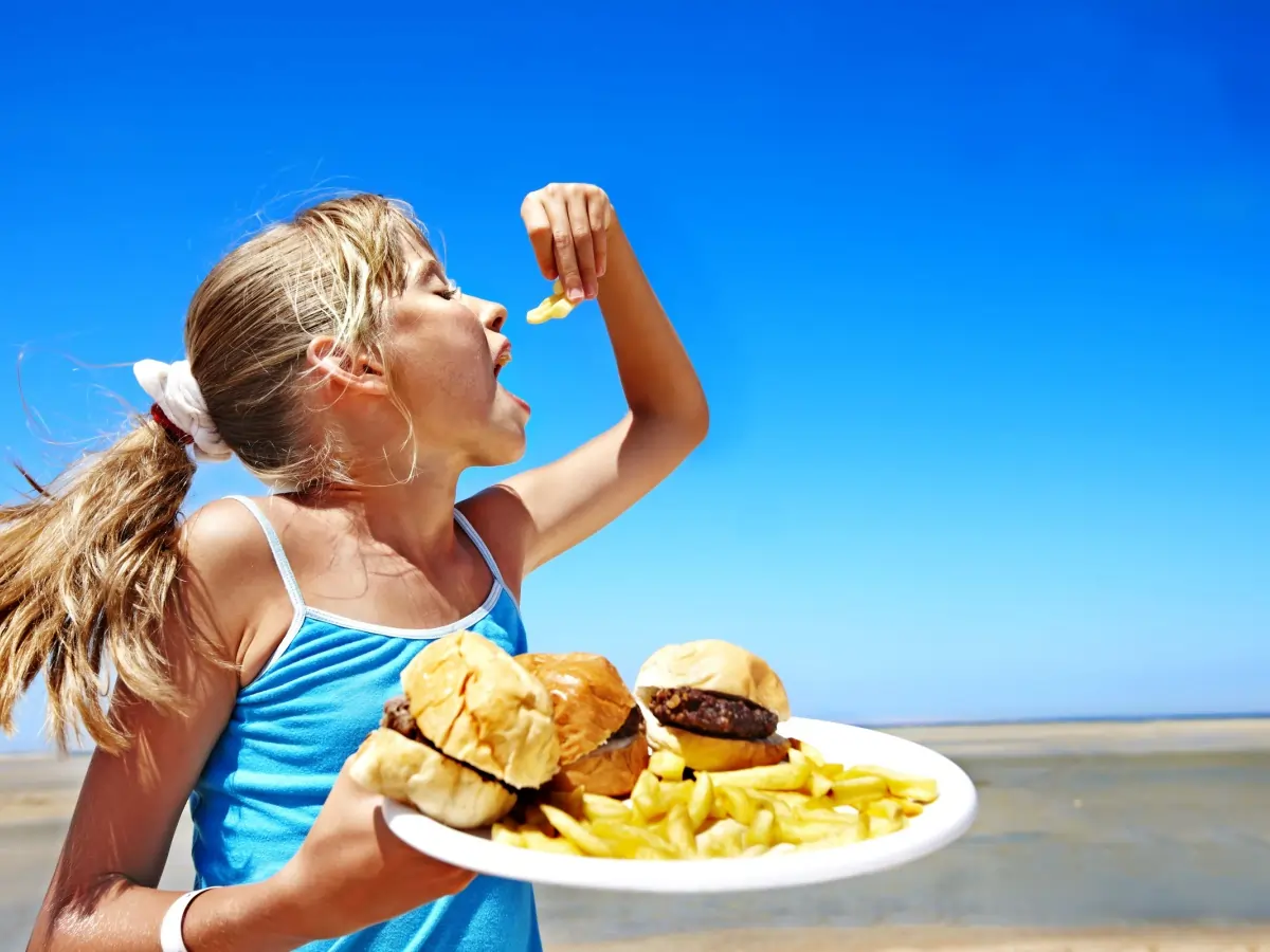 girl on beach with burger